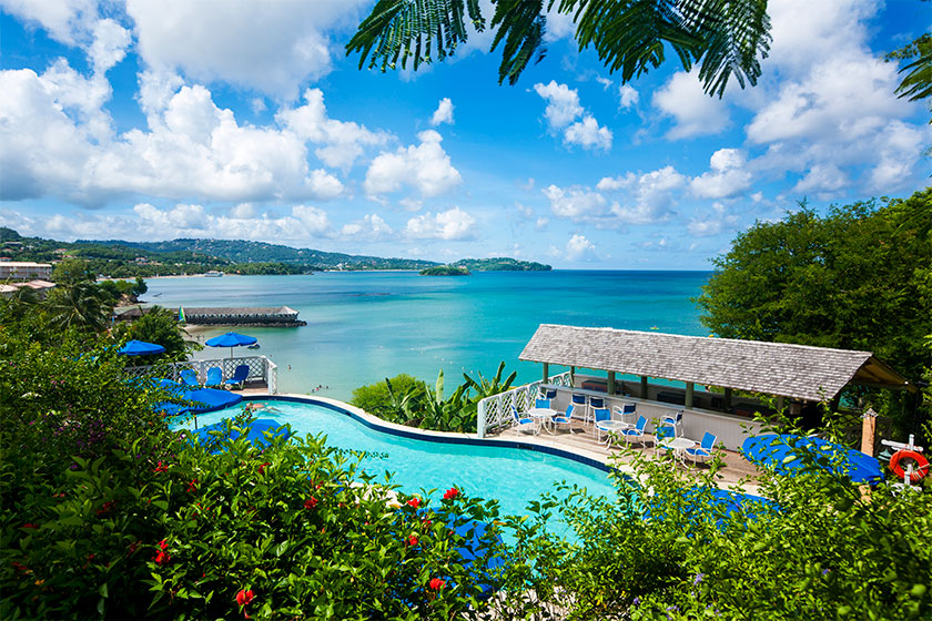 View of pool, beach, and ocean from an all inclusive resort.