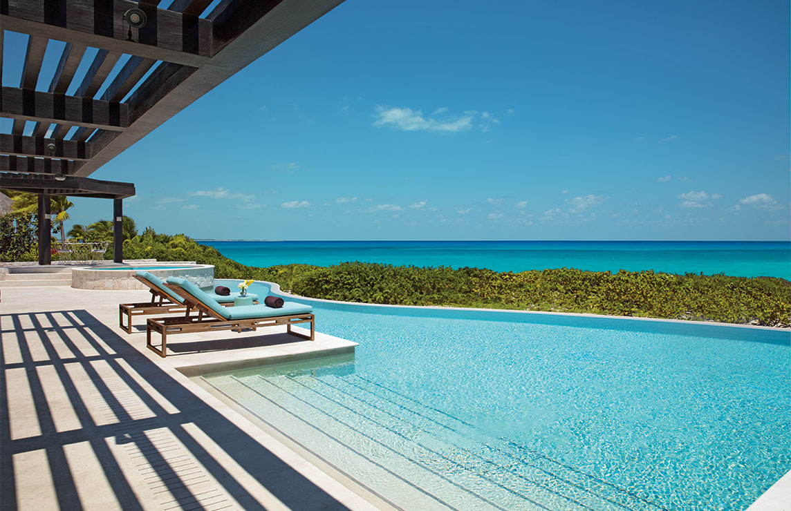 Luxury resort view of hotel pool and of the ocean.