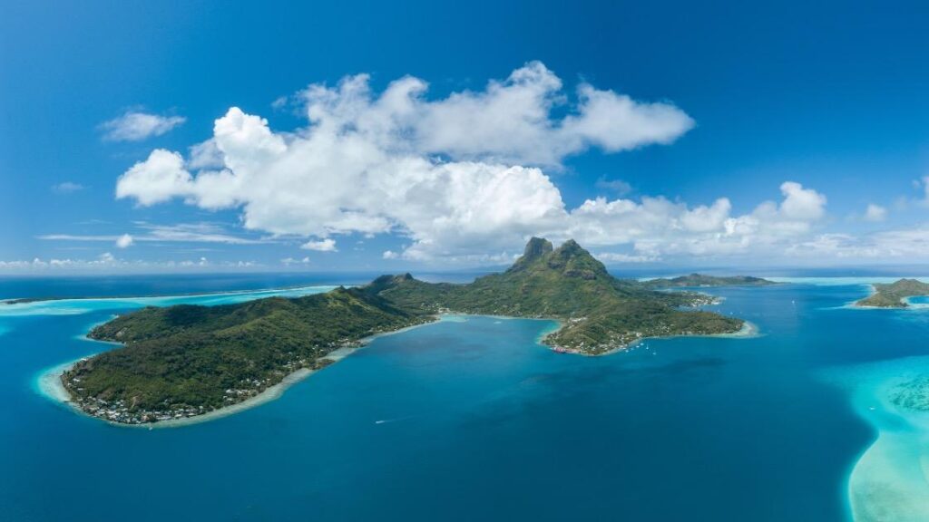 Turquoise lagoon and palm-covered islets of Bora Bora, French Polynesia.